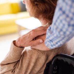 close up of caregiver with hand on woman's shoulder