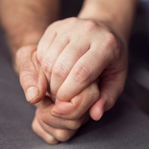 Old and young person holding hands. Elderly care and respect, selective focus