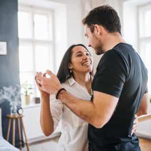 couple dancing at home together smiling