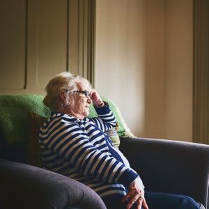 senior woman sitting at home alone