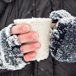 Frozen hands holding a mug