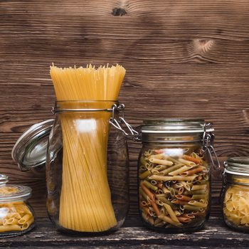 Pasta macaroni concept background. Pasta in a glass jar container.