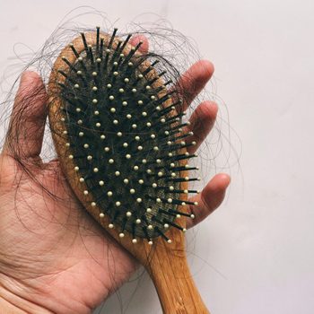 Hair loss inside wood comb brush, on hand