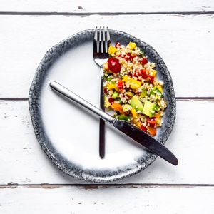 plate with fork and knife resembling a clock for intermittent fasting concept