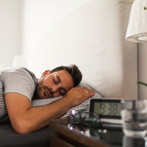 man sleeping clock on nightstand do you need 8 hours of sleep