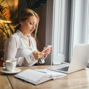 woman working and procrastinating on cell phone