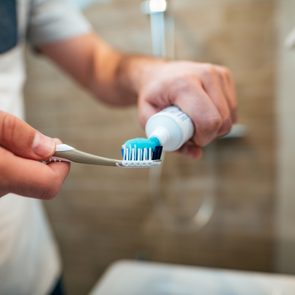 putting toothpaste on toothbrush