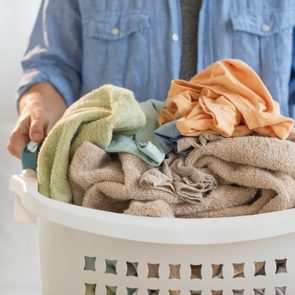 close up of man holding laundry hamper