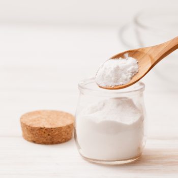 close up of baking soda in jar with wooden spoon