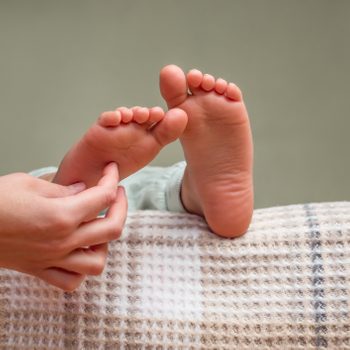 close up of hand tickling child's feet