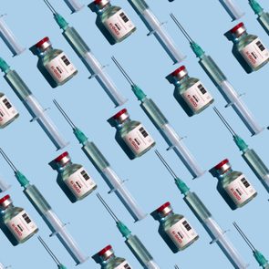 Repeated vials and syringes with covid-19 vaccine on the blue background