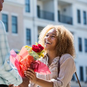 Young man gives flowers to girlfriend