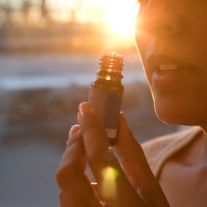 Woman holding essential oil bottle