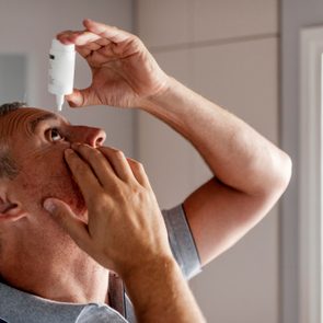 Mature Man Putting Eye Drops In Eyes