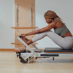 Woman Doing Pilates Exercise on Reformer