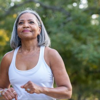 Senior woman jogging in public park