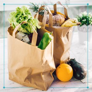 paper shopping bags filled with groceries sitting on a kitchen counter