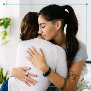 two females hugging each other on bed