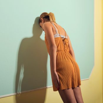 Rear View Of Sad Woman Leaning On Wall