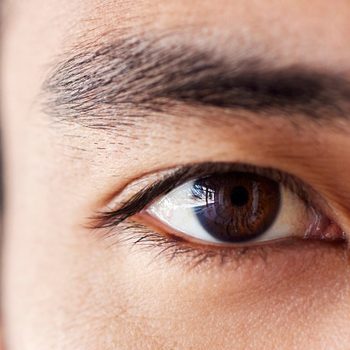 Closeup Portrait Of A Handsome Young Mixed Race Man Standing At Work In An Office Job. Young Hispanic Male With Naturally Long Eyelashes And Neat Eyebrows Showing His Healthy Brown Eye