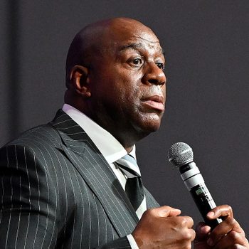 Magic Johnson holding a mircrophone while speaking at a conference